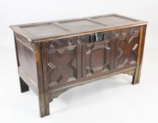 An 18th century carved oak coffer, the front with triple geometric moulded panels, W.4ft