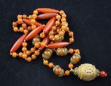 A single strand gilt metal mounted amber bead necklace, with elongated and round beads and carved