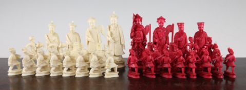 A 19th century carved ivory canton chess set, with natural ivory opposing red stained ivory figures,