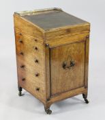 A Regency rosewood and boxwood inlaid davenport, the sliding top with three quarter pierced brass