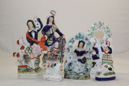 Four Staffordshire flatback groups and a pair of figures of sheep, mid 19th century, the first