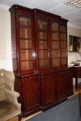 A Victorian mahogany breakfront bookcase, with four glazed doors above four cupboard doors, on