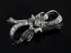 An 18ct white gold and diamond set bow brooch, with central floral motif, 1.5in.