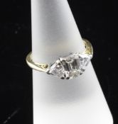 An 18ct gold and three stone diamond ring, the central emerald cut stone flanked by two trillion cut