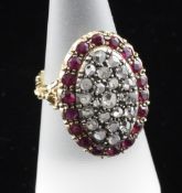 A Victorian style 18ct gold, ruby and diamond pave dress ring, of oval form, with carved shank and