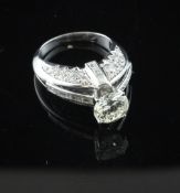 A white gold and solitaire diamond ring, with round brilliant and baguette cut diamond set pierced