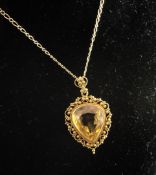 A 14ct gold and citrine pendant, on a 9ct gold chain, the pear shaped stone set within a cannetile