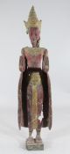 A large Thai gilt and polychrome standing figure of Buddha, his hands pressed forward in front of