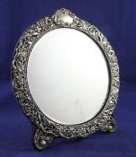 An Edwardian repousse silver mounted circular easel mirror, decorated with foliate scrolls, Henry