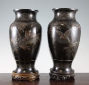 A pair of Japanese inlaid bronze vases, Meiji period, each applied with a bird amid wisteria, the