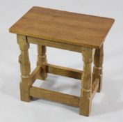 A Robert `Mouseman` Thompson oak stool, with rectangular adzed top, with octagonal shaped legs,