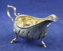 A George III Irish silver sauceboat, with fluted and bead decoration, on hoof feet with scroll