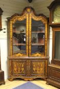 A 19th century Dutch marquetry inlaid corner cabinet, with two glazed doors over two cupboard doors,
