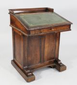 An early 19th century rosewood davenport, the sloping hinged top revealing a fitted interior above