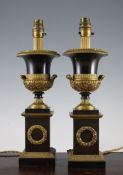 A pair of French bronze and ormolu campana urn table lamps, on square sectioned plinth bases, 15in.