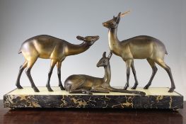 Attributed to Irenee Rochard. A French Art Deco patinated metal group of three deer, on a