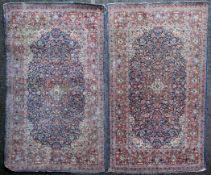 A pair of 1920`s Kashan rugs, with central foliate motif within a field of scrolling foliage on a