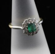 An 18ct gold and platinum, emerald and diamond cluster ring, size M.