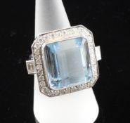 An 18ct white gold large aquamarine and diamond set dress ring, the stepped square cut aquamarine