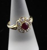 An 18ct gold, ruby and diamond cluster ring, of flowerhead design, with carved shoulders, size M.