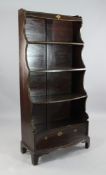 An early 19th century simulated rosewood and painted waterfall bookcase, with four shelves and