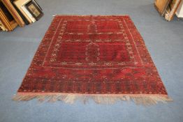 An Afghan rug, with four panels of hooked motifs on a red ground, with multi row geometric and