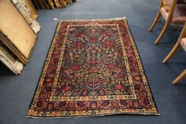 A Kashan "tree of life" rug, with polychrome decoration on a deep blue ground, with three row