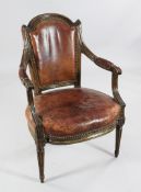 A Louis XVI beech fauteuil, with moulded frame and tan leather upholstered back and seat, on