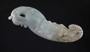 A Chinese archaic celadon and brown jade `dragon` plaque, the stone with calcification to one end,