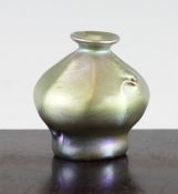 A Louis Comfort Tiffany art glass vase, of dimpled `sack` form, in iridescent pale green, signed LCT