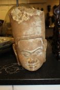 A Khymer style stone head, with pendulous ear lobes, slight smile and tall hat, 13.75in.