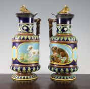 A pair of George Jones majolica ewers and covers, late 19th century, the cylindrical bodies
