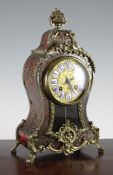 An early 20th century Louis XV style red boulle mantel clock, with enamelled tablet numerals and A.