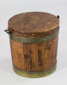A brass bound oak planter or pail, with brass swing handle, circular top and rising lid, overall W.