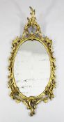 A George III oval gilt wall mirror, with pierced scrolling frame and acanthus crest, H.4ft 1in.