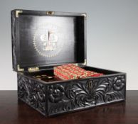 A 19th century Ceylonese carved ebony work box, decorated allover with scrolling leaves and