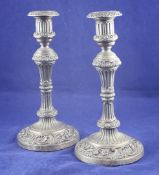 A pair of George III silver candlesticks, with fluted waisted stems and foliate scroll circular