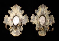 A pair of Italian carved and painted girandoles, with central oval mirrors and twin scrolled