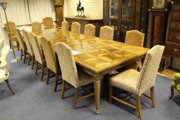 A large European parquetry inlaid extending dining table, with one extra leaf, on tapering square