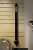 An early 18th century style mahogany stick barometer, with silvered scale, concealed tube and demi-