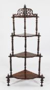 A Victorian walnut four tier corner whatnot, with tapering spiral turned uprights and turned legs,