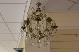 A scrolling brass electrolier, with pear shaped glass drops and flowerhead sconces, 22in.