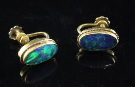 A pair of 9ct gold and black opal doublet earclips, of oval form with rope twist border, 0.5in.