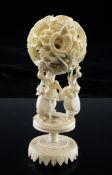 A Chinese ivory concentric ball and stand, early 20th century, the outer ball carved with