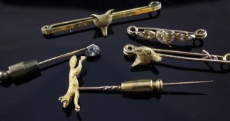 Three Edwardian 15ct gold fox mounted stock pins, a diamond set stick pin and a seed pearl set