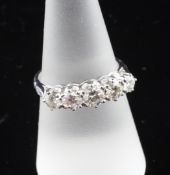 An 18ct white gold and graduated five stone diamond half hoop ring, with diamond set shoulders and a