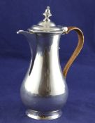 A George II silver hot water jug, of baluster form, with turned finial and rattan handle, Charles