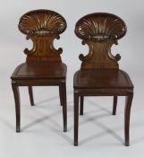A pair of early 19th century mahogany hall chairs, attributed to Gillows, with scallop shaped