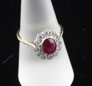 An 18ct gold, ruby and diamond cluster ring, of oval form, size O.