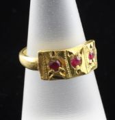 A 22ct gold and three stone ruby ring, with rectangular carved setting, size M.